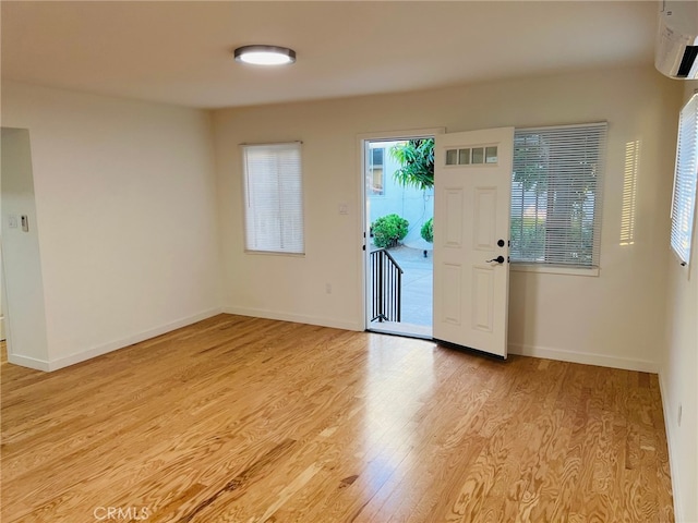 entryway featuring light hardwood / wood-style floors and an AC wall unit