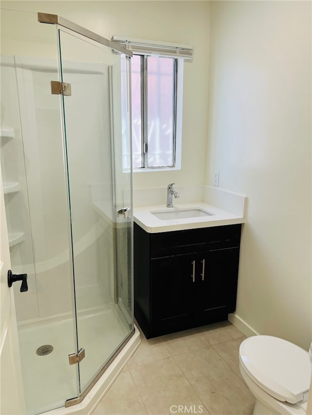 bathroom with vanity, tile patterned floors, a shower with shower door, and toilet