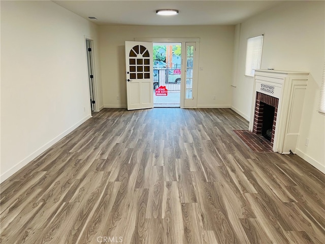 unfurnished living room featuring a fireplace and hardwood / wood-style flooring