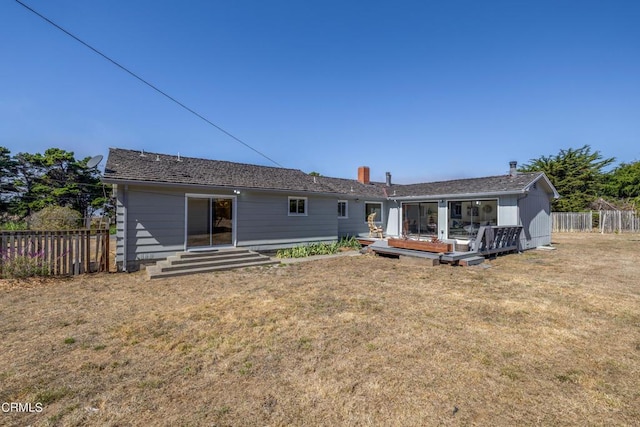 rear view of property with a deck and a lawn