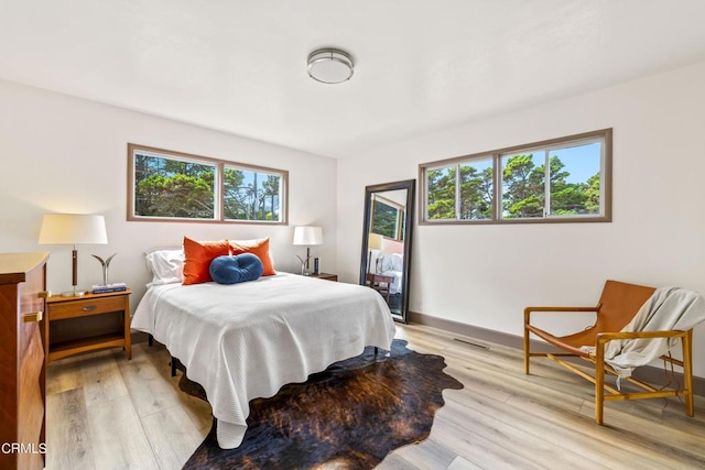 bedroom featuring light hardwood / wood-style floors and multiple windows