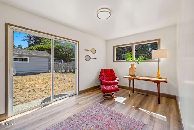 living area with light wood-type flooring and a healthy amount of sunlight