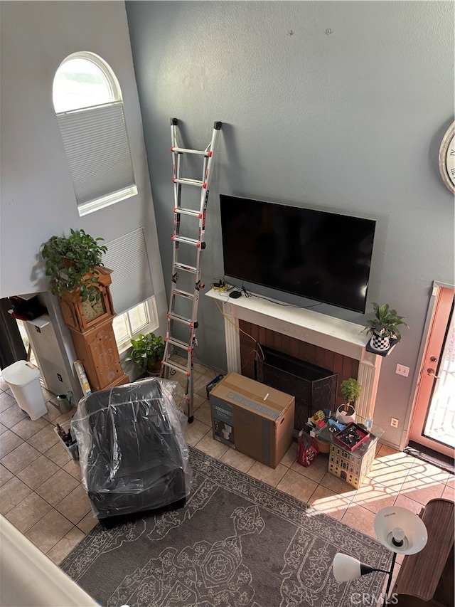 living room featuring a tiled fireplace, a healthy amount of sunlight, and tile patterned floors