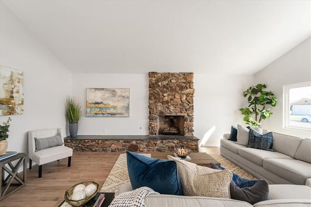 living room featuring a fireplace, vaulted ceiling, and hardwood / wood-style flooring