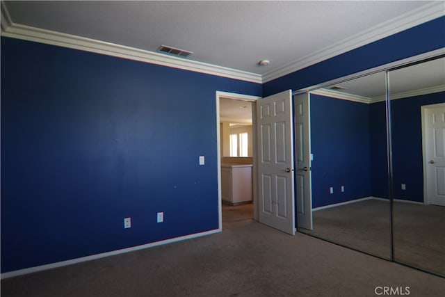 unfurnished bedroom featuring a textured ceiling, carpet, crown molding, and a closet