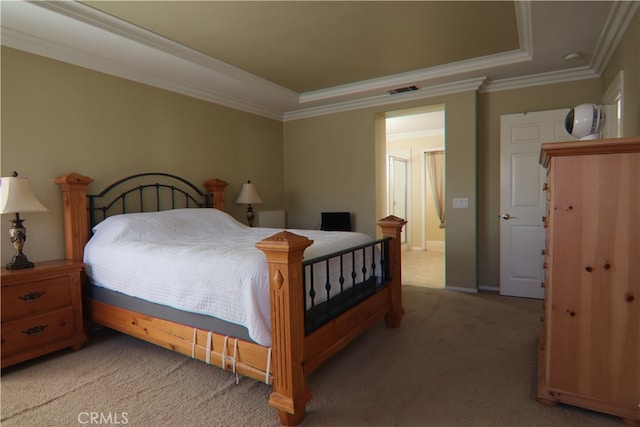 carpeted bedroom with ornamental molding and a tray ceiling