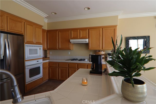 kitchen featuring white appliances, ornamental molding, and tile countertops