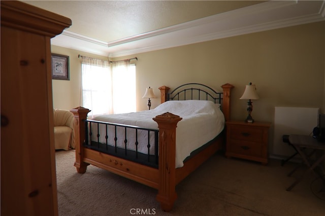 carpeted bedroom with ornamental molding and a raised ceiling