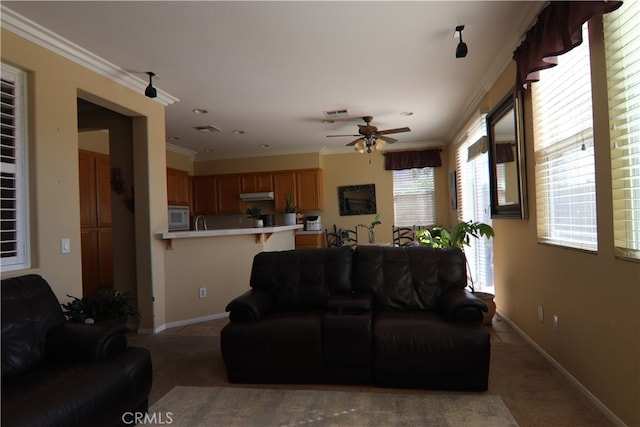 carpeted living room with ceiling fan and ornamental molding