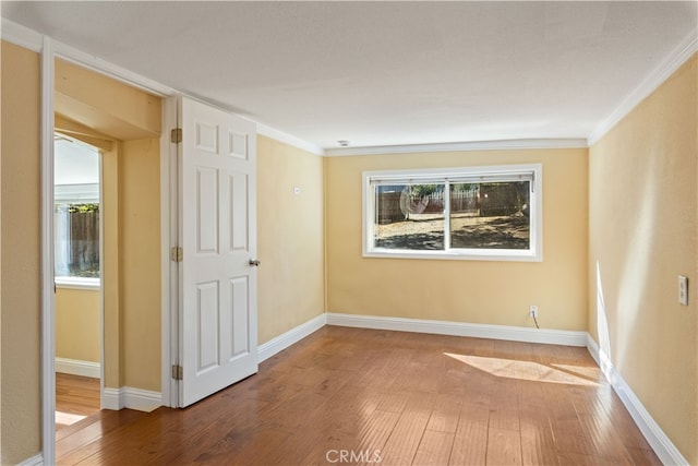 empty room with crown molding and hardwood / wood-style floors