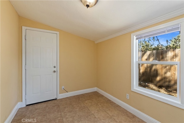 empty room featuring lofted ceiling and crown molding