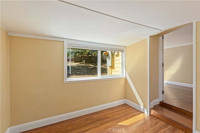 empty room featuring wooden walls and hardwood / wood-style floors