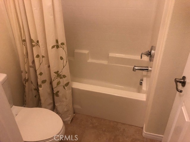 bathroom featuring tile patterned floors, toilet, and shower / tub combo with curtain