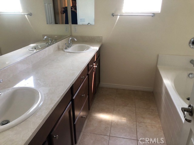 bathroom with vanity, a tub to relax in, and tile patterned floors