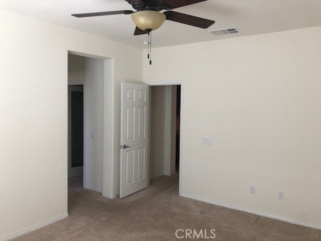 unfurnished bedroom with ceiling fan and light carpet