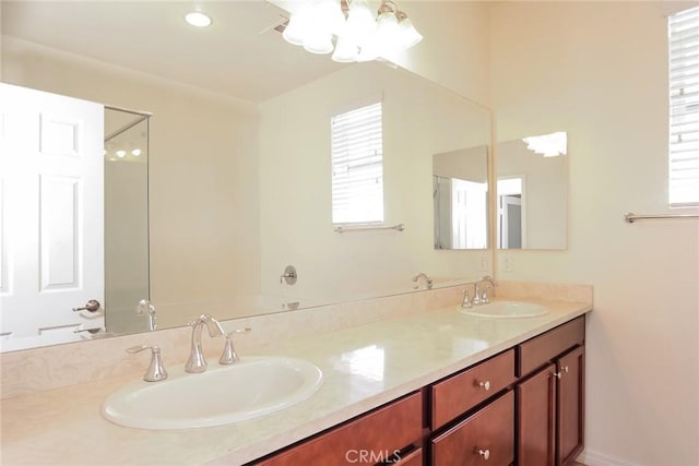 full bathroom featuring a healthy amount of sunlight, a sink, and double vanity