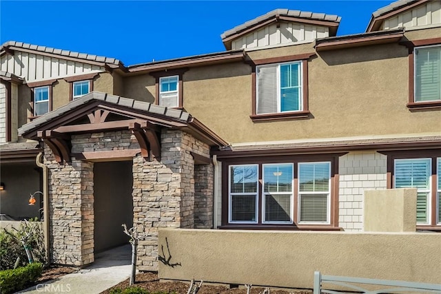 view of front of property featuring stone siding and stucco siding