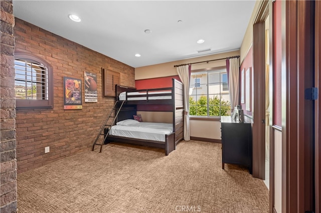 carpeted bedroom with brick wall