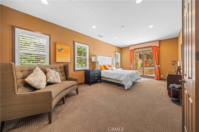 carpeted bedroom featuring multiple windows and access to exterior