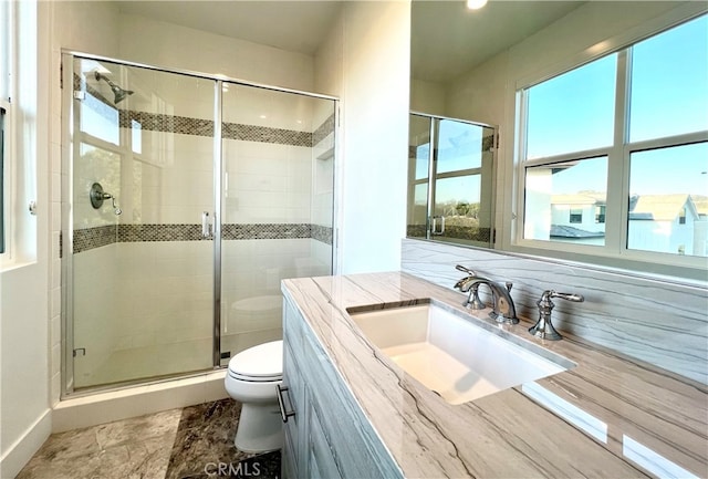 bathroom with a shower with shower door, vanity, and toilet