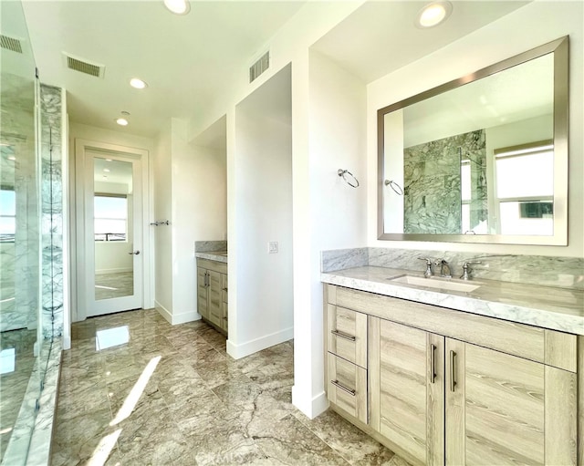 bathroom featuring a wealth of natural light, vanity, and tiled shower