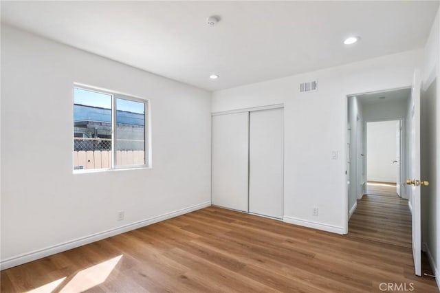 unfurnished bedroom with wood-type flooring and a closet