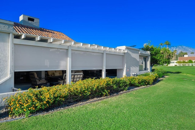 view of property exterior with a yard and a pergola