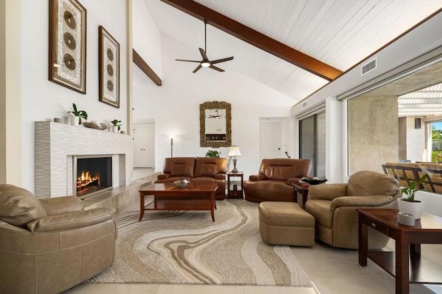 living room featuring ceiling fan, a fireplace, beam ceiling, and high vaulted ceiling