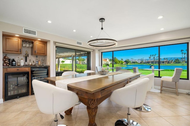 dining room with bar area, beverage cooler, and light tile patterned flooring