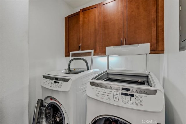 laundry area featuring washing machine and dryer and cabinets