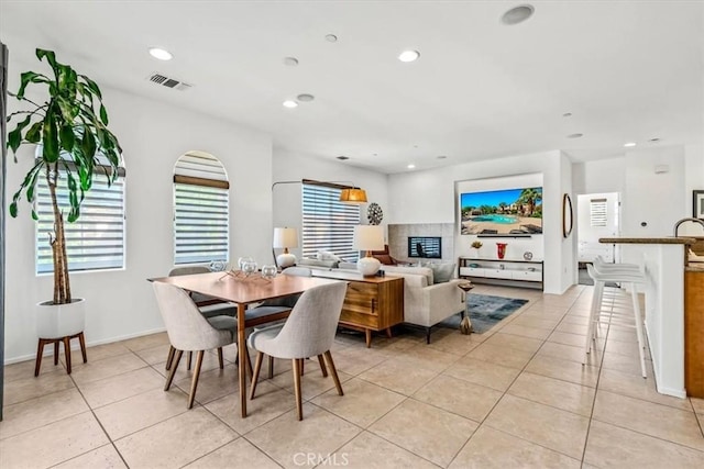 dining space featuring light tile patterned flooring and a fireplace