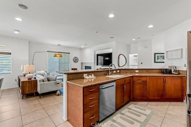 kitchen with stainless steel dishwasher, light tile patterned flooring, sink, and dark stone counters