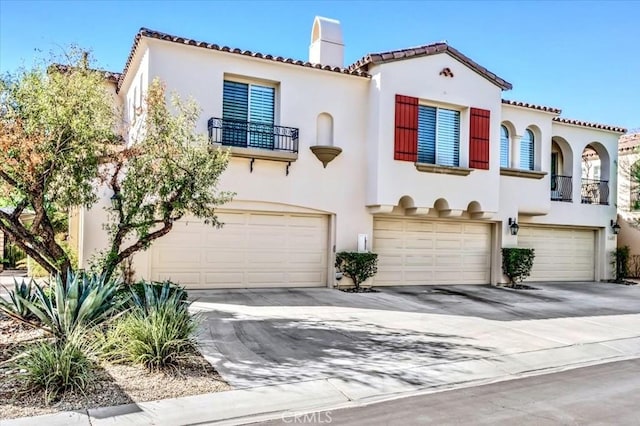 mediterranean / spanish-style home with a balcony and a garage