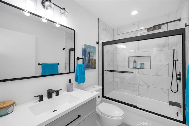 full bathroom with vanity, enclosed tub / shower combo, and toilet