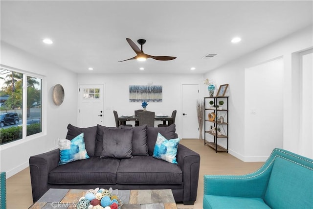 living room featuring light hardwood / wood-style flooring and ceiling fan