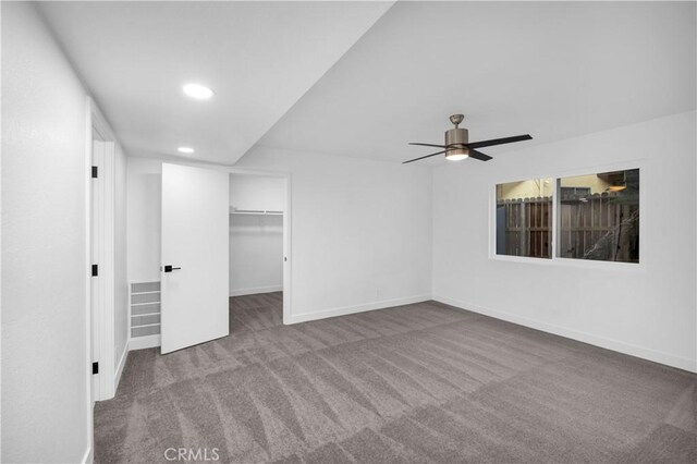 unfurnished bedroom with ceiling fan, a spacious closet, carpet floors, and a closet