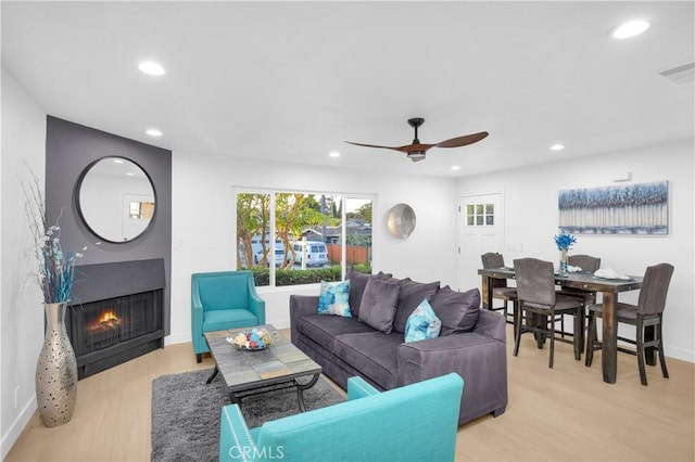 living room featuring ceiling fan and light hardwood / wood-style floors