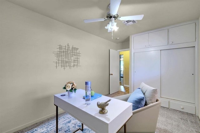 home office featuring light carpet and ceiling fan