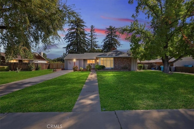 ranch-style home featuring a lawn and a garage