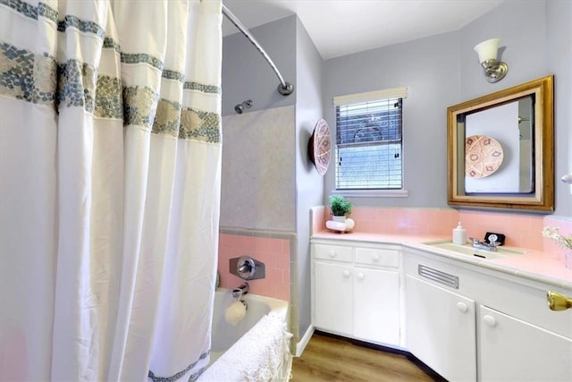 bathroom featuring hardwood / wood-style floors, vanity, and shower / bathtub combination with curtain