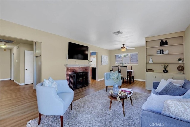 living room featuring a fireplace, hardwood / wood-style floors, and ceiling fan