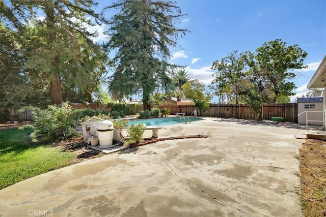 view of patio / terrace with a fenced in pool and a storage shed