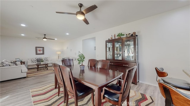 dining area with light hardwood / wood-style floors and ceiling fan