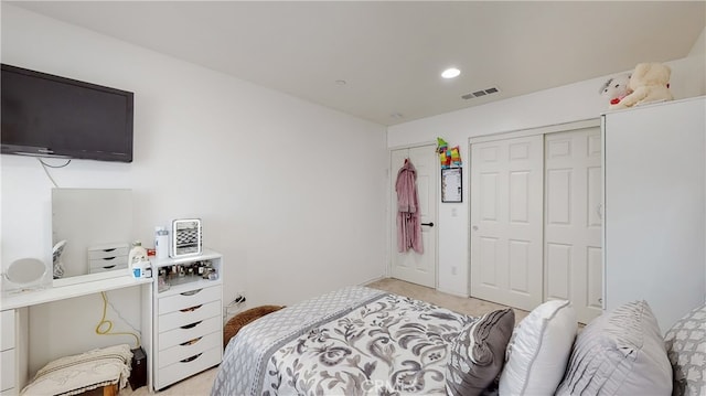 bedroom featuring light carpet and a closet