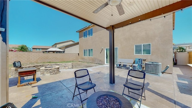 view of patio with ceiling fan, central air condition unit, and a fire pit