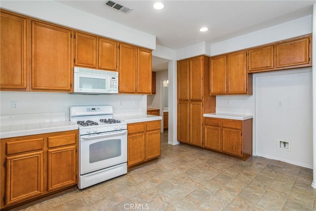 kitchen with tile counters and white appliances