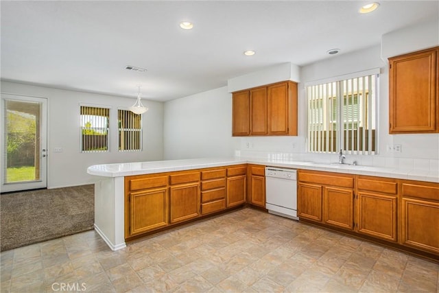 kitchen featuring kitchen peninsula, light carpet, white dishwasher, sink, and pendant lighting