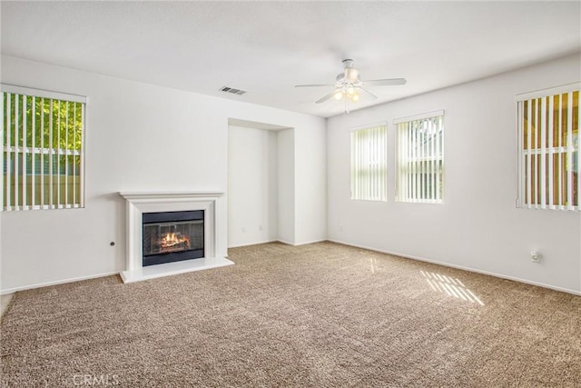 unfurnished living room featuring carpet floors and ceiling fan