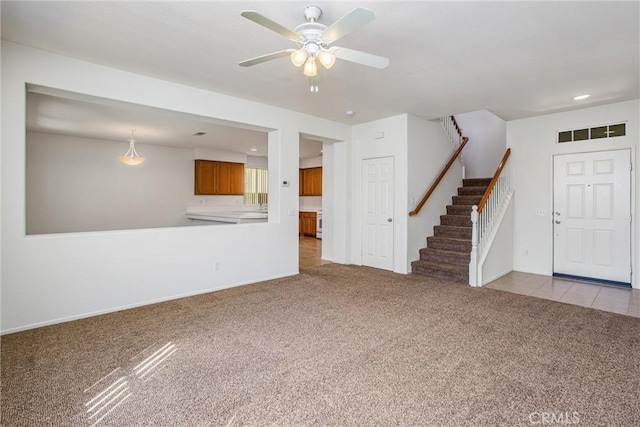 unfurnished living room featuring light carpet and ceiling fan