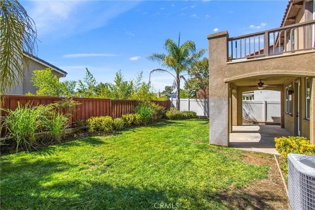 view of yard featuring ceiling fan, a balcony, cooling unit, and a patio